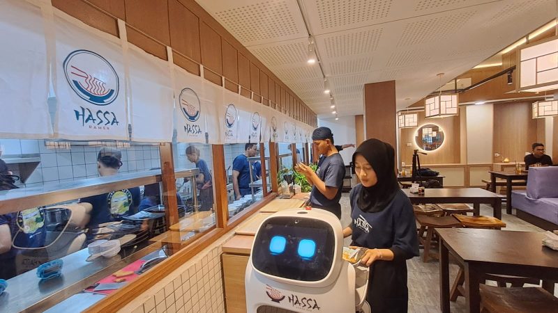 Pelayanan sedang meletakkan makanan di atas robot untuk diantar ke meja pengunjung. Foto: Fakhrur/intimes.co.id